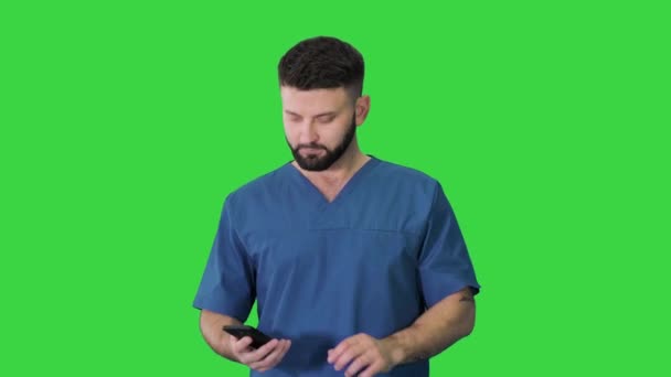 Cerrah doktor yürüyor ve telefonunu yeşil ekranda kullanıyor, Chroma Key. — Stok video