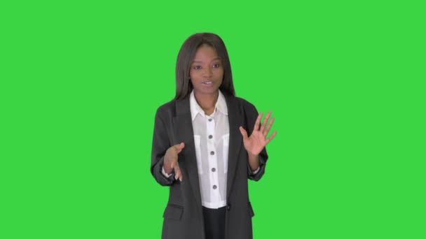 緑の画面、クロマキーを歩いている間にアフリカ系アメリカ人のビジネスマンの女性が説明し、ジェスチャー. — ストック動画