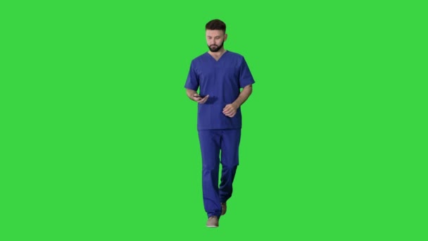 Médico cirujano caminando y usando su teléfono en una pantalla verde, Chroma Key . — Vídeo de stock