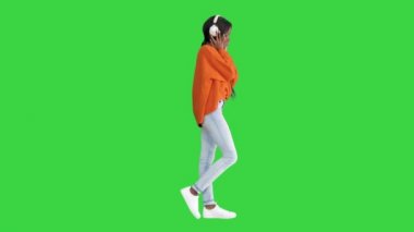 Kulaklıklı genç Afro-Amerikalı kadın Yeşil Ekran, Chroma Key 'de müzik dinliyor..