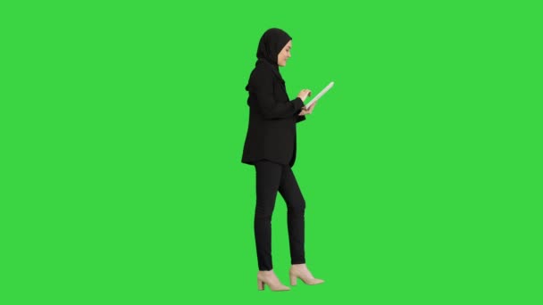 緑の画面、クロマキーを歩いている間にタブレットコンピュータを使用してかわいいアラビア人の実業家. — ストック動画
