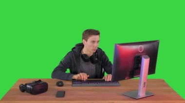 Genç oyuncu yeşil ekran, Chroma Key 'deki kameraya doğru bakıyor..