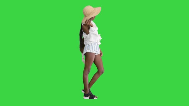 Lächelnde junge Afroamerikanerin mit Strohhut posiert auf einem Green Screen, Chroma Key. — Stockvideo