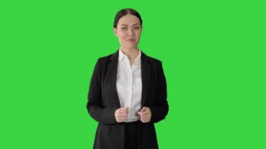 Gülümseyen iş kadını Yeşil Ekran 'da yürürken, Chroma Anahtarı' nı açıklarken ve işaret ederken.