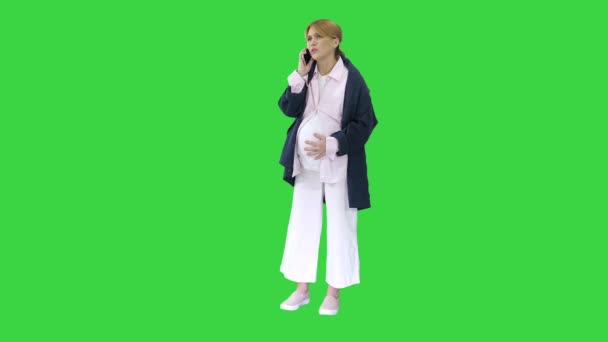 Gravid kvinna med sammandragningar smärta ringer ambulans med mobiltelefon på en grön skärm, Chroma Key. — Stockvideo