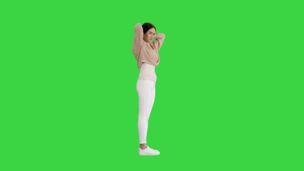 Mooie vrouw met het bevestigen van haar korte bruine haar op een groen scherm, Chroma Key. — Stockvideo