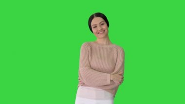 Yeşil Ekran 'da kollarını kavuşturmuş gülümseyen genç kadın, Chroma Key.