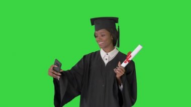 Gülümseyen Afrikalı Amerikalı kadın mezunlar Yeşil Ekran 'da diplomasıyla selfie çekiyorlar, Chroma Key.