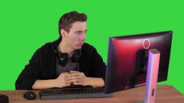 Ciddi bir oyuncu bilgisayarda oturmuş Yeşil Ekran 'da maç izliyor, Chroma Key.