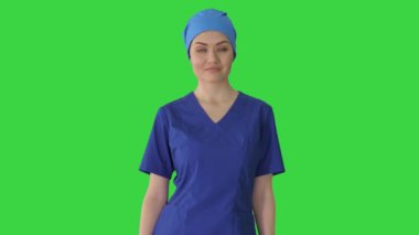 Kendine güvenen hemşire ya da mavi üniformalı doktor yeşil ekran Chroma Key 'de kameraya doğru yürüyor..