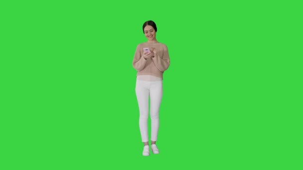 Chroma Key, улыбаясь молодой девушке на мобильном телефоне и смеясь на зеленом экране. — стоковое видео