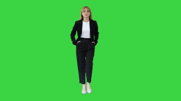 Donna d'affari ambulante con le mani in tasca su uno schermo verde, Chroma Key. — Video Stock