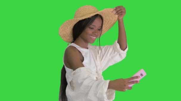 緑色の画面、クロマキーを歩いている間に自撮りを取り藁帽子でアフリカ系アメリカ人の女性を笑顔. — ストック動画