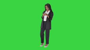 Güzel siyahi iş kadını telefonuna mesaj atıyor ve yeşil ekranda gülümsüyor, Chroma Key.