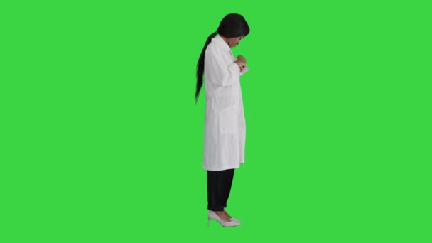 Jeune jolie médecin femme noire fixant son badge sur un écran vert, Chroma Key. — Video