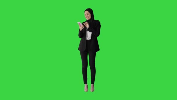 Moslim meisje in hijab met behulp van smartphone om spraakberichten te sturen op een groen scherm, Chroma Key. — Stockvideo