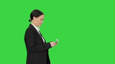Takım elbiseli genç bir kadın yeşil ekranda para sayıyor, Chroma Key..