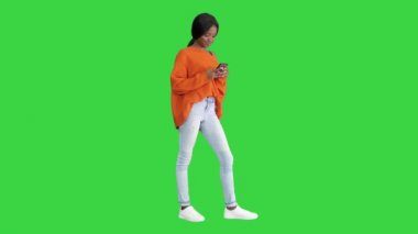 Telefonunu yeşil ekranda kullanan güzel bir genç kadın, Chroma Key..