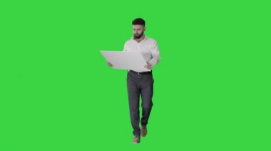 İşadamı yürüyor ve yeşil ekran, Chroma Key 'in planına bakıyor..