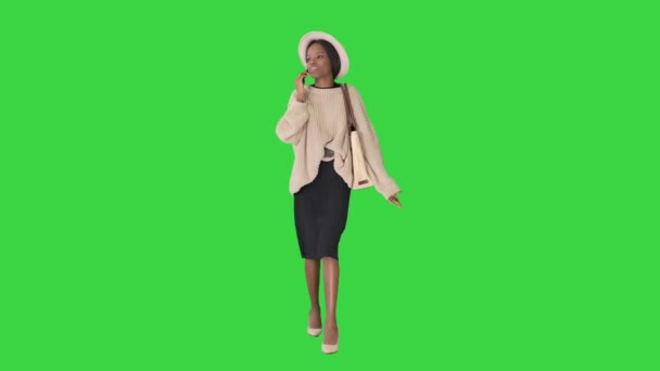 Mujer afroamericana frustrada en suéter de punto y sombrero blanco hablando en su teléfono en una pantalla verde, Chroma Key. — Vídeos de Stock