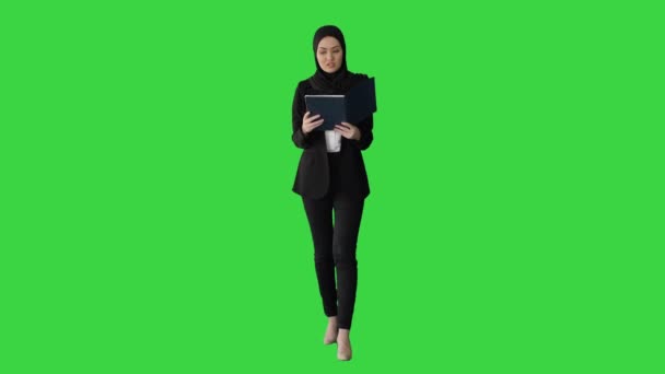 Μουσουλμάνα επιχειρηματίας που διαβάζει τον επιχειρηματικό της σχεδιασμό ενώ περπατά προς τη συνάντηση σε μια πράσινη οθόνη, Chroma Key. — Αρχείο Βίντεο