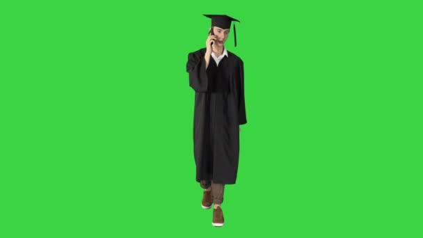 Feliz estudiante graduado caminando y haciendo una llamada en una pantalla verde, Chroma Key . — Vídeo de stock