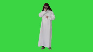 Arap işadamı sesli mesaj kaydediyor veya Yeşil Ekran, Chroma Key üzerinde sesli dijital yardımcı kullanıyor.
