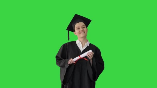 Felice studentessa in vestaglia laurea a piedi e tifo con il suo diploma su uno schermo verde, Chroma Key. — Video Stock