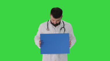 Arap doktor pankart gösteriyor ve yeşil ekranda bir şey söylüyor, Chroma Key.