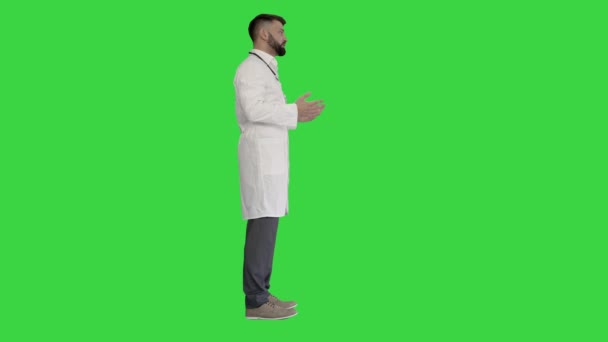 Selbstbewusster Arzt im Gespräch mit jemandem auf einem Green Screen, Chroma Key. — Stockvideo