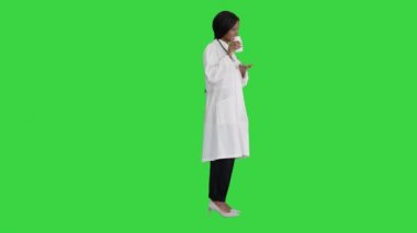 Gülümseyen Afro-Amerikan kadın doktor steteskop ile Yeşil Ekran, Chroma Key 'de ilaç reklamı yapıyor..