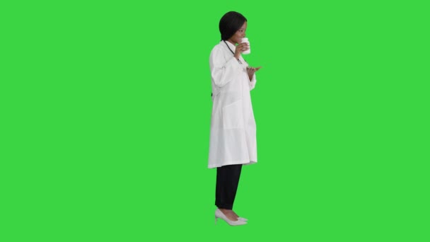 Sonriente mujer afroamericana médico con estetoscopio publicidad de la medicina en una pantalla verde, Chroma Key. — Vídeos de Stock