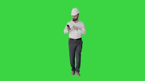 Yeşil Ekranda yürüyen ve akıllı telefon kullanan bir mühendis, Chroma Key. — Stok video