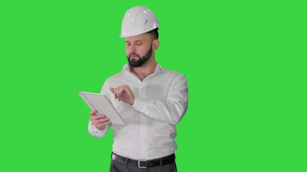 Ειδικός κατασκευών χρησιμοποιώντας έναν υπολογιστή tablet ενώ περπατάτε σε μια πράσινη οθόνη, Chroma Key. — Αρχείο Βίντεο