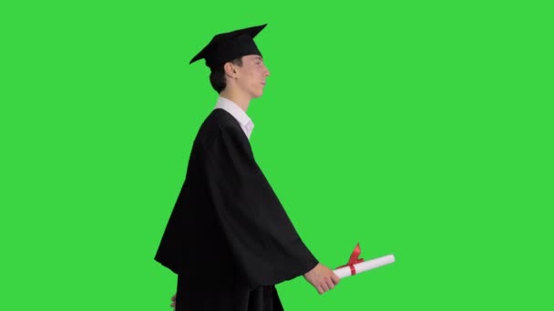 Végzős diák sétál és mosolyog a zöld képernyőn, Chroma Key. — Stock videók