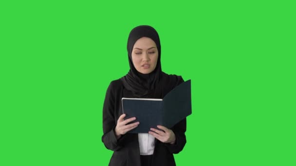 Moslim Zakenvrouw leest haar business planner tijdens het lopen naar de vergadering op een groen scherm, Chroma Key. — Stockvideo