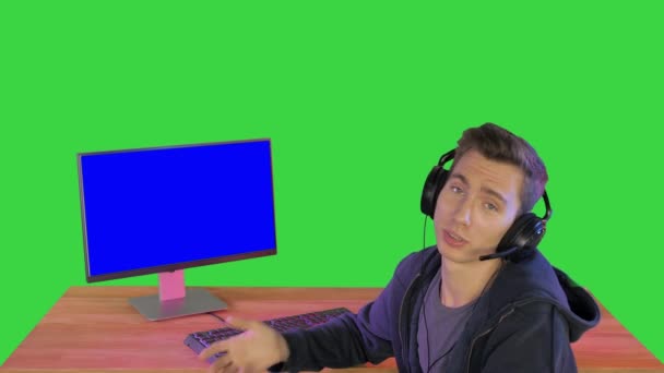 Gamer praten over het spel op het scherm om camera op een groen scherm, Chroma Key. — Stockvideo