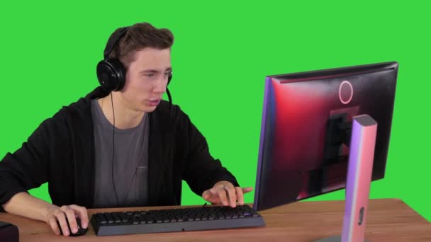 プロのゲーマーは、彼のコンピュータ上でビデオゲームをプレイし、緑の画面、クロマキーで彼のストリームをコメント. — ストック動画