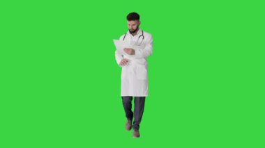 Doktor yeşil ekranda yürürken hastanın tıbbi raporunu okuyor, Chroma Key..