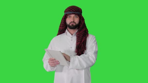 Sheikh presentar información o producto utilizando tableta digital en una pantalla verde, Clave de croma. — Vídeos de Stock
