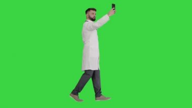Doktor yeşil ekranda yürürken akıllı telefonuyla selfie çekiyor, Chroma Key.
