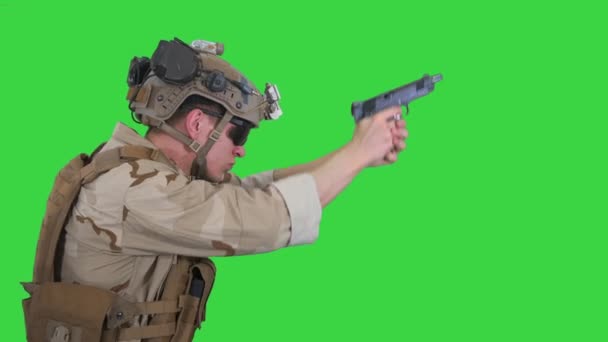 Soldier aiming and shooting with a pistol on a Green Screen, Chroma Key. — Stock Video