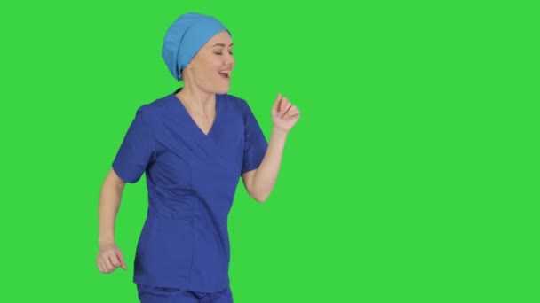 Médecin femme souriante en uniforme bleu dansant et acclamant sur un écran vert, Chroma Key. — Video