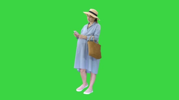 Mujer embarazada en el noveno mes usando un teléfono inteligente en una pantalla verde, Chroma Key. — Vídeo de stock