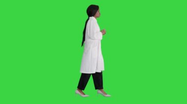 Genç Afrikalı Amerikalı kadın doktor yeşil ekranda yürürken konuşuyor, Chroma Key.