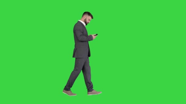 Επιχειρηματίας περπάτημα και μηνύματα κειμένου σε μια πράσινη οθόνη, Chroma κλειδί. — Αρχείο Βίντεο