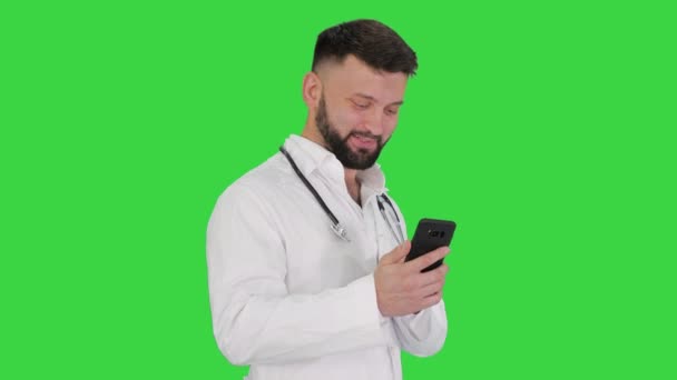 Médico árabe andando usando smartphone e rindo em uma tela verde, Chroma Key . — Vídeo de Stock