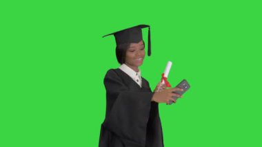 Mezun olmuş mutlu Afrikalı kadın diploması ve yeşil ekranda özçekim yapıyor, Chroma Key.