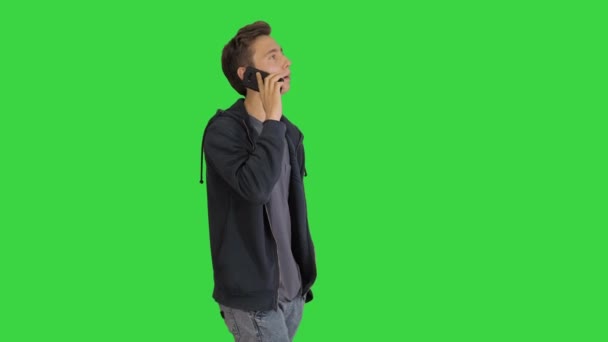 Случайный человек разговаривает по мобильному телефону во время прогулки по зеленому экрану, Chroma Key. — стоковое видео