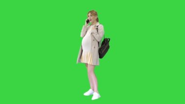 Hamile öğrenci yeşil ekranda cep telefonuyla konuşuyor, Chroma Key..